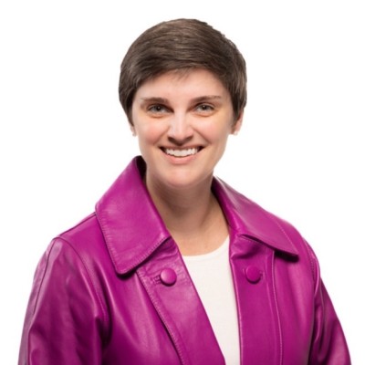 Alison Kaufmann, Old Dominion Electric Cooperative. A smiling person with short brown hair wearing a bright purple leather jacket over a white top, posed against a plain white background.