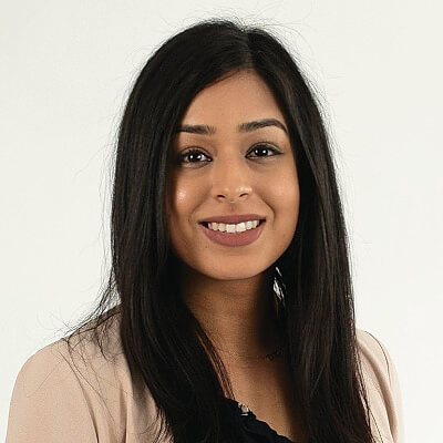 Angeli Jaipargas, Independent Electricity System Operator. A woman with long, straight dark hair smiles at the camera. She is wearing a light-colored blazer over a black top, and the background is plain white.