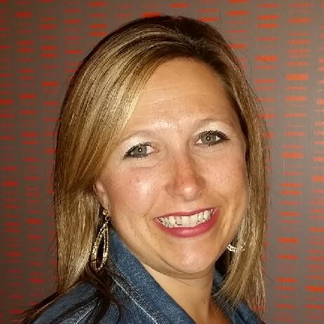 Melissa Dziurawiec, Lynxspring. A woman with straight blonde hair, wearing a denim jacket and hoop earrings, smiles at the camera against a gray background with a pattern of small orange horizontal lines.
