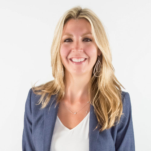 Lynn Ames, GM. A woman with long blonde hair wearing a blue blazer and white blouse smiles at the camera against a plain white background.