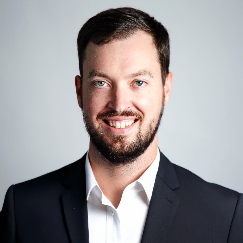 Doug Lindsey, EPRI. Smiling man with short brown hair and beard wearing a dark suit and white shirt against a plain light background.