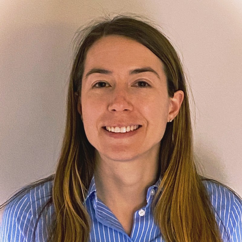 Andrea Goodman, Eversource. A woman with long brown hair, wearing a blue striped shirt, smiles at the camera in front of a plain light background.
