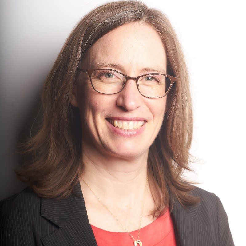 Debbie Driscoll, Northwest Energy Efficiency Alliance (NEEA) . Woman with shoulder-length brown hair, glasses, and a black blazer smiles in front of a plain white background.